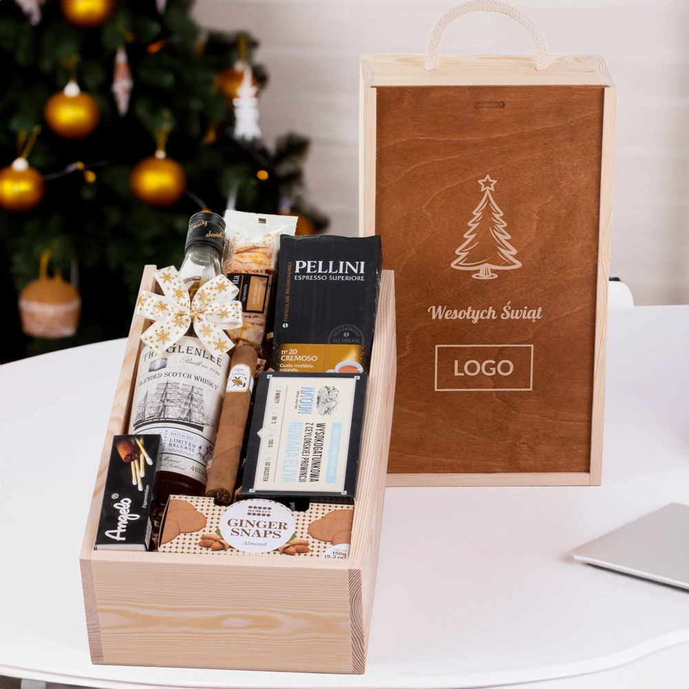 Ekskluzywny upominek bożonarodzeniowy w eleganckiej drewnianej skrzynce z wyraźnym grawerem logo, zawierający wysokiej jakości produkty: whisky, kawę, herbatę, słodkości i cygaro; zestaw ozdobiony świąteczną kokardą, idealny na prezent firmowy.