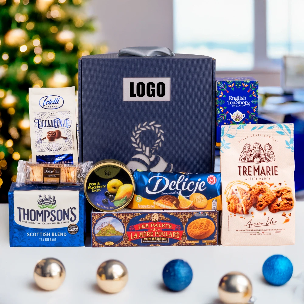 Granatowy kosz świąteczny z logo firmy, zawierający herbaty (Thompson's, English Tea Shop), włoskie i francuskie ciasteczka, delicje oraz owoce w syropie. Elegancki prezent firmowy na Boże Narodzenie z możliwością personalizacji.